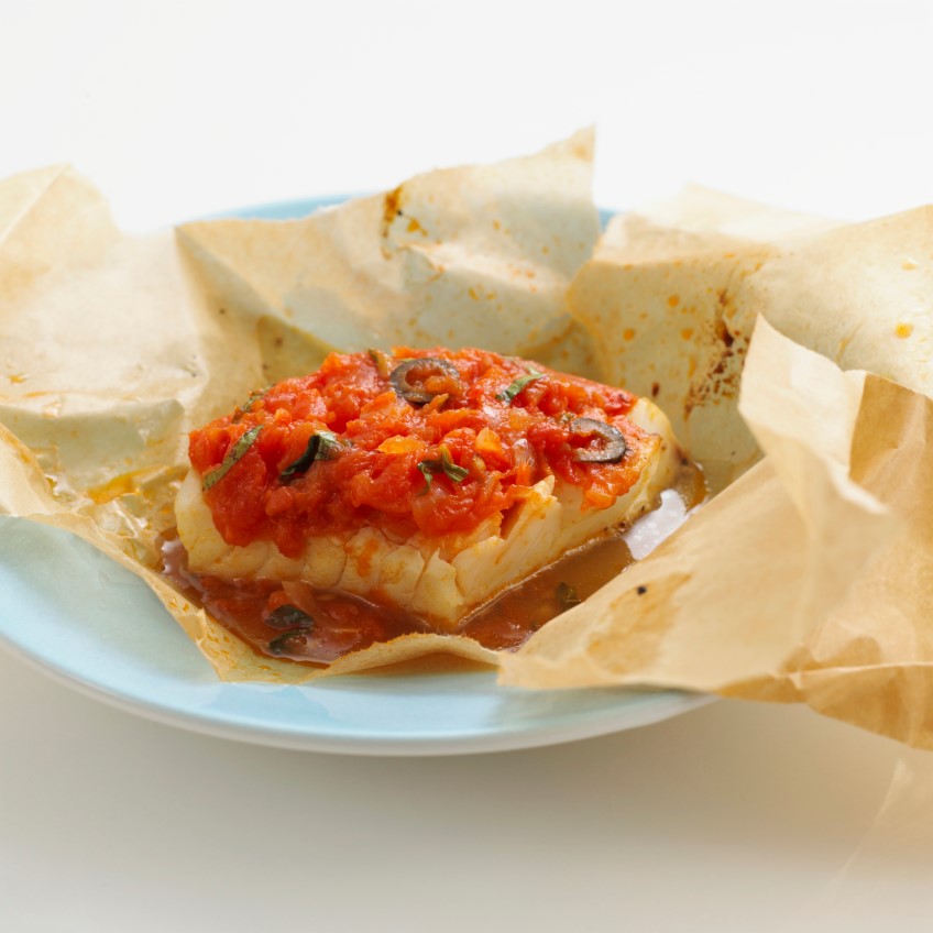 Fish baked in paper with olives and tomatoes